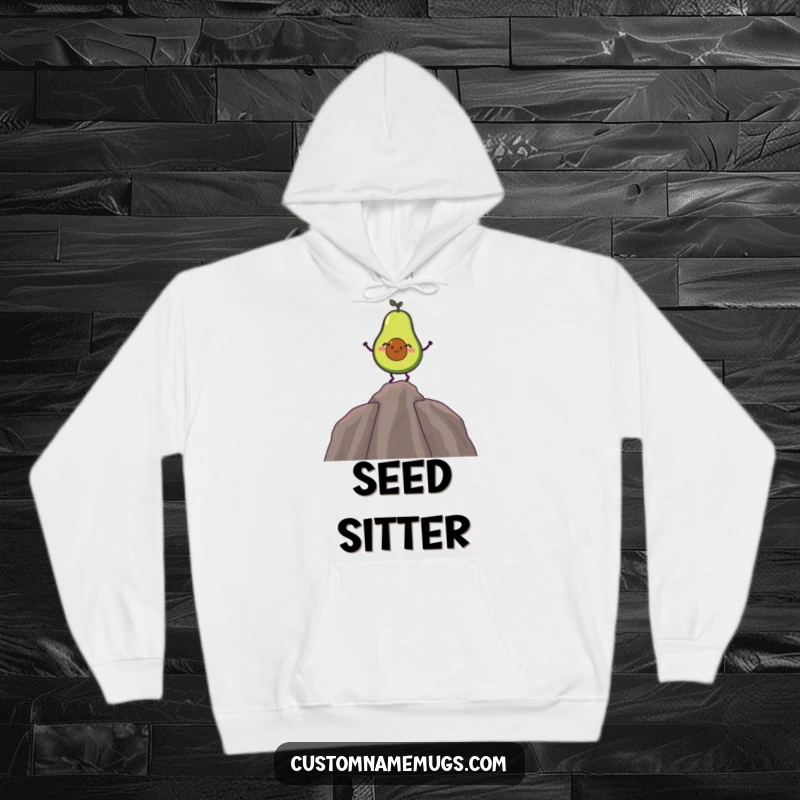 Funny hoodie with a giggling avocado character balancing on its pit, offering warmth and comical charm.